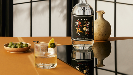 A bottle of Four PIllar's Gin's Changing Season's gin next to a Bijou cocktail in a Japanese restaurant.