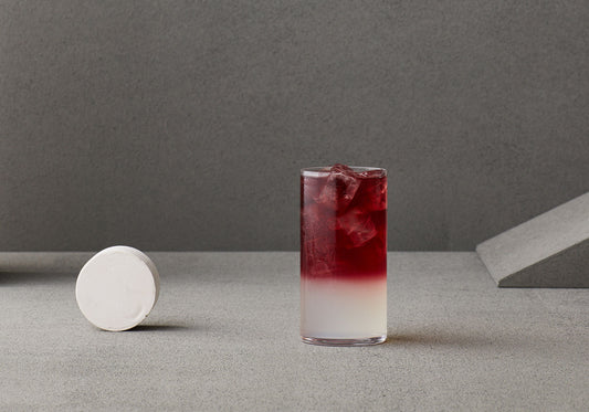 A cool looking red coloured gin and soda cocktail in a tall glass.
