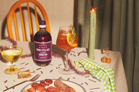 A festive Christmas table setting with a bottle of Bloody Shiraz Gin and Douglas Fir gin cocktail.