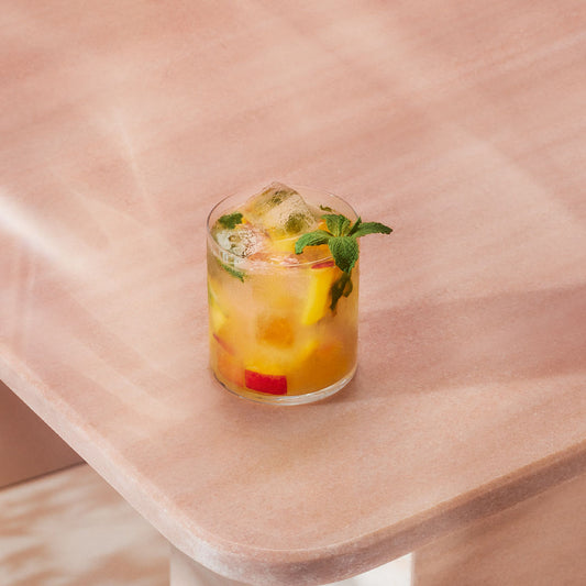 A delicious looking peach smash gin cocktail, a gin version of a mojito.