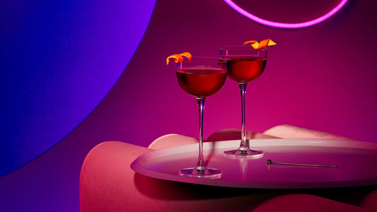 Two red gin martinis with an orange twist for garnish made with Bloody Pinot Noir Gin.
