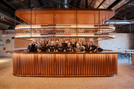 The bar at the Four Pillars Gin distillery with the Four Pillars staff posing with it.