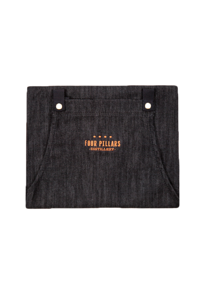 A folded Four Pillars black cotton Denim Apron with Copper Embroidery