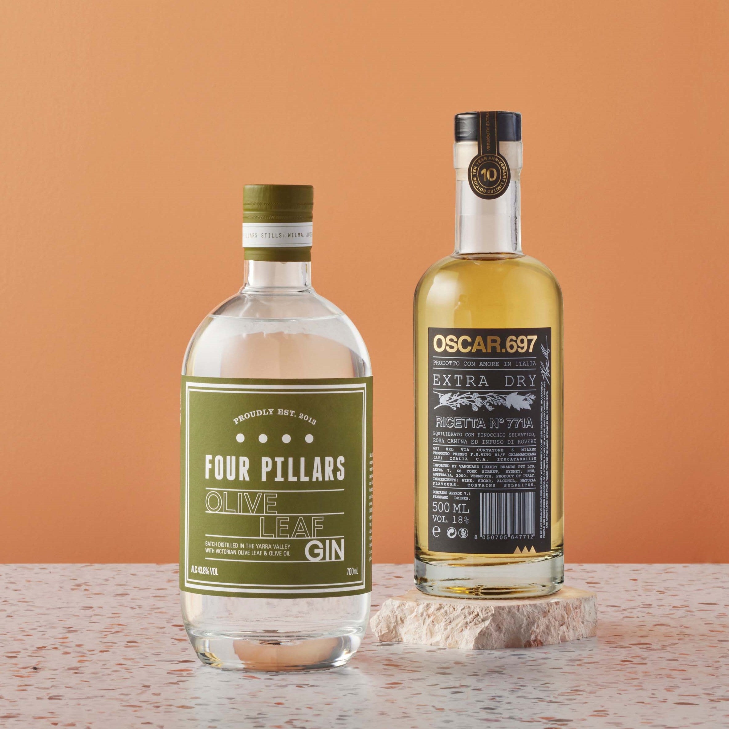 A bottle of Four Pillars Olive Leaf Gin and a bottle of Oscar.697 Extra Dry Vermouth
