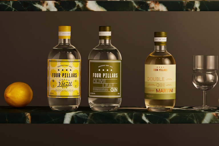 Two marble shelves with 3 bottles of Four Pillars Gin sitting on one, Fresh Yuzu Gin, Olive Leaf Gin and the bottled cocktail Double Gin Martini.