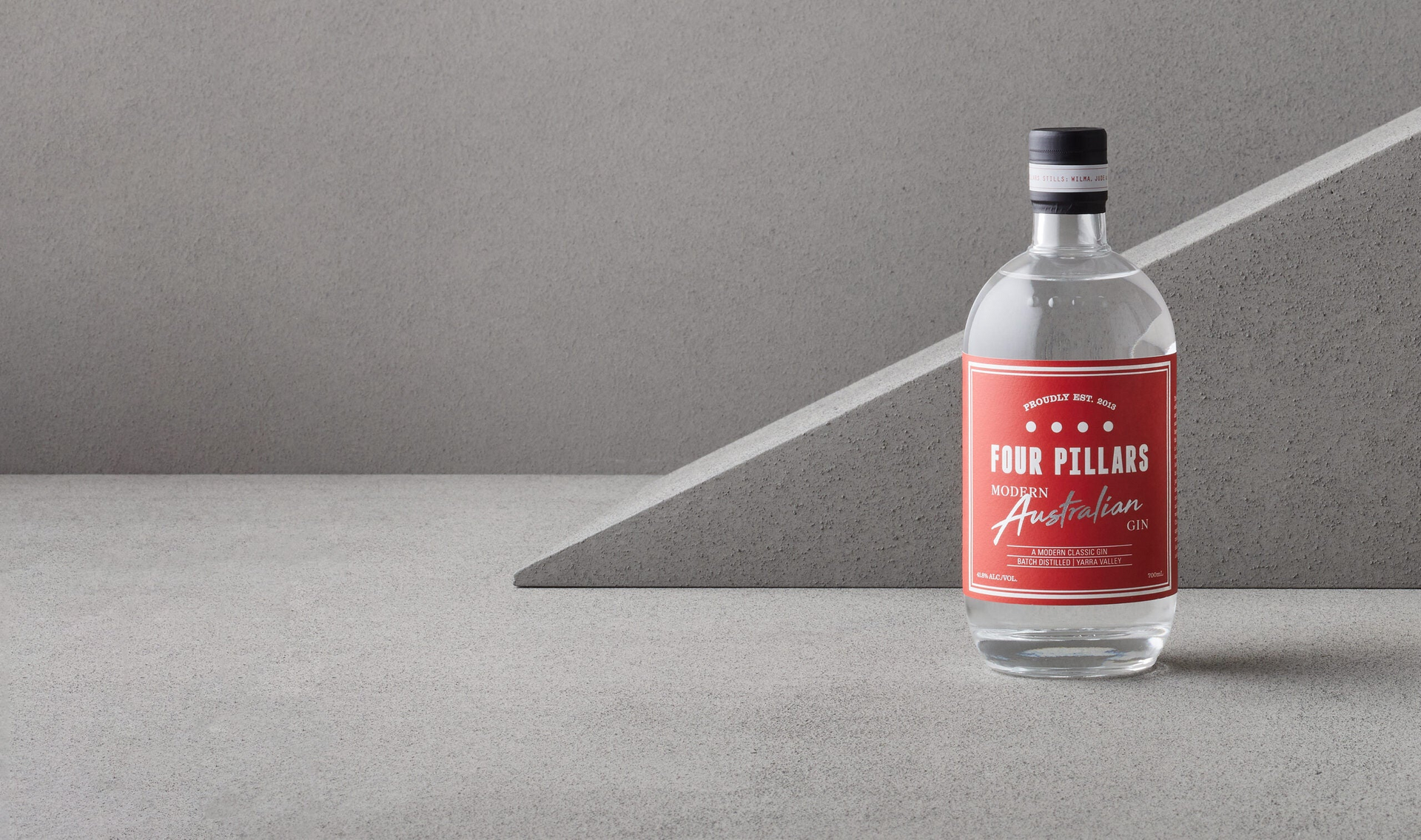 Four Pillars Gin, Modern Australian Gin with its bold red label, surrounded by grey cement.