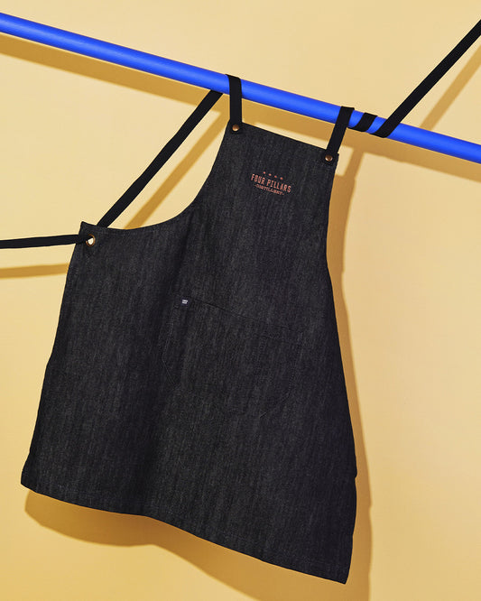 A hanging Four Pillars black cotton Denim Apron with Copper Embroidery