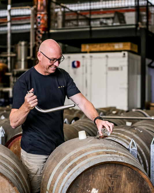 Cam Mackenzie with a wine barrel, ageing gin. 