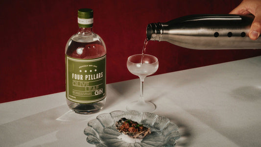 A mini Martini is poured into a glass, made with Four Pillars Olive Leaf Gin and paired with a unique snack.