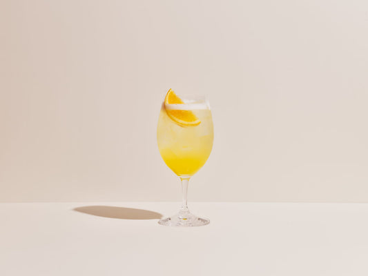 A wine glass filled with a Mimosa made with Rare Dry Gin.