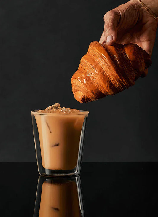 A latte glass filled with a delicious gin-spiked Almond Latte cocktail made with Croissant Gin.