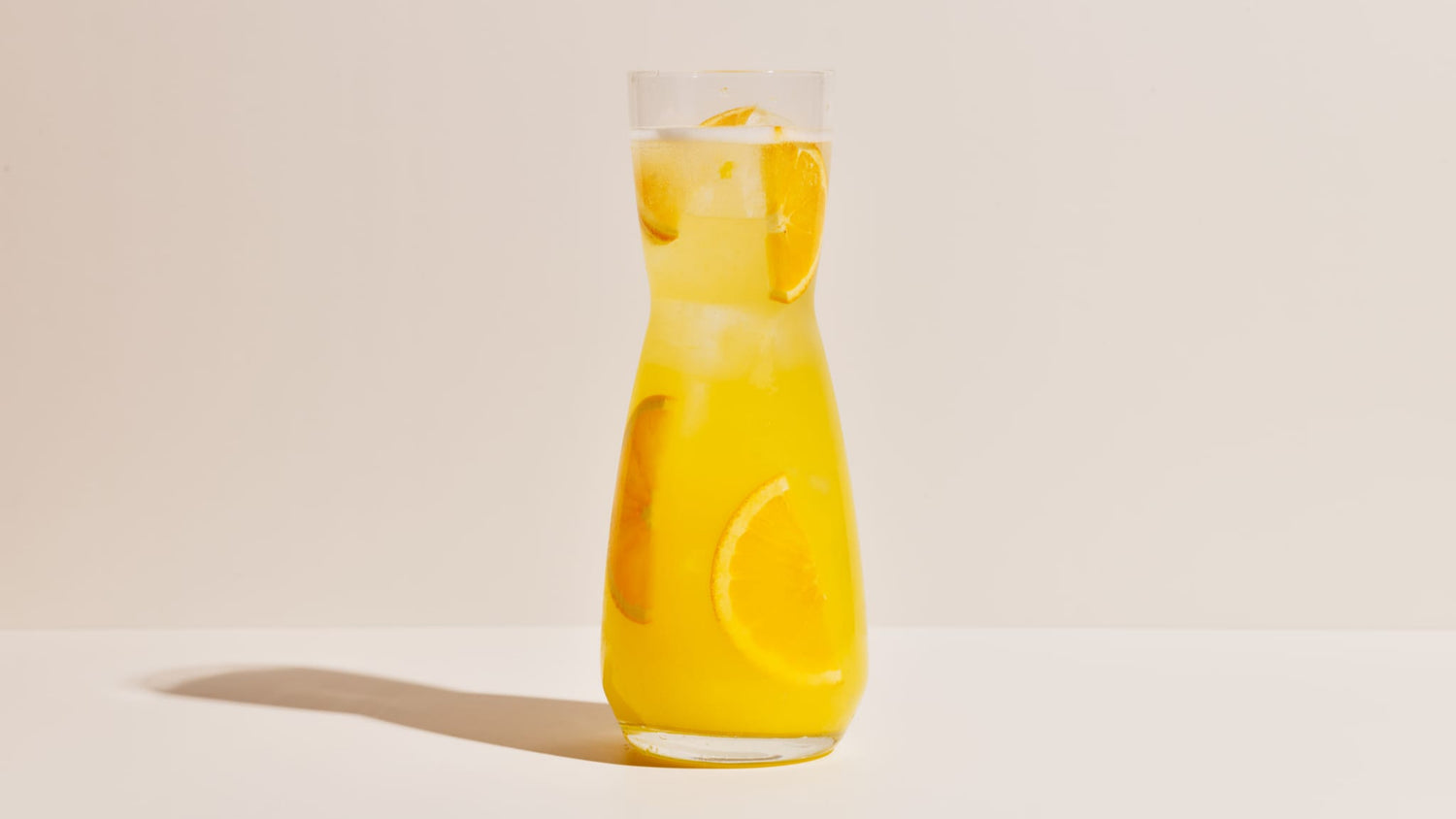 A large carafe sits on a white background, containing a shared-style Mimosa-inspired cocktail made with Four Pillars Rare Dry Gin.
