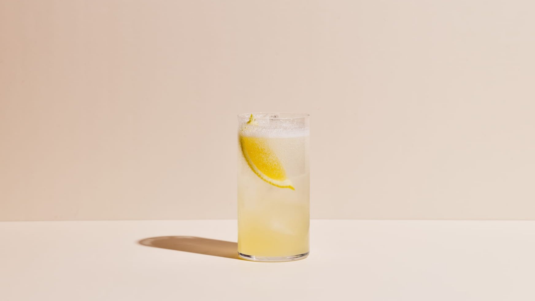 A tall glass containing a fizzy cocktail made with Four Pillars Fresh Yuzu Gin