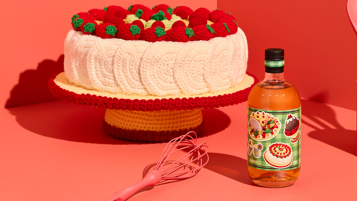 A crocheted Christmas pavlova and Four Pillars Australian Christmas Gin sit against a red backdrop