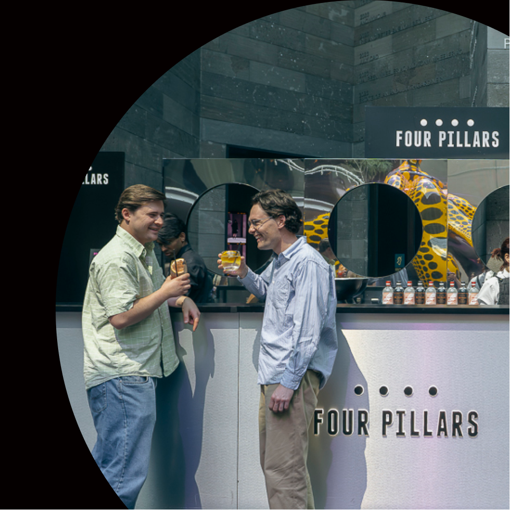 Promotional graphic for NGV Friday Nights event with two people at a bar, featuring 'Four Pillars' branding.