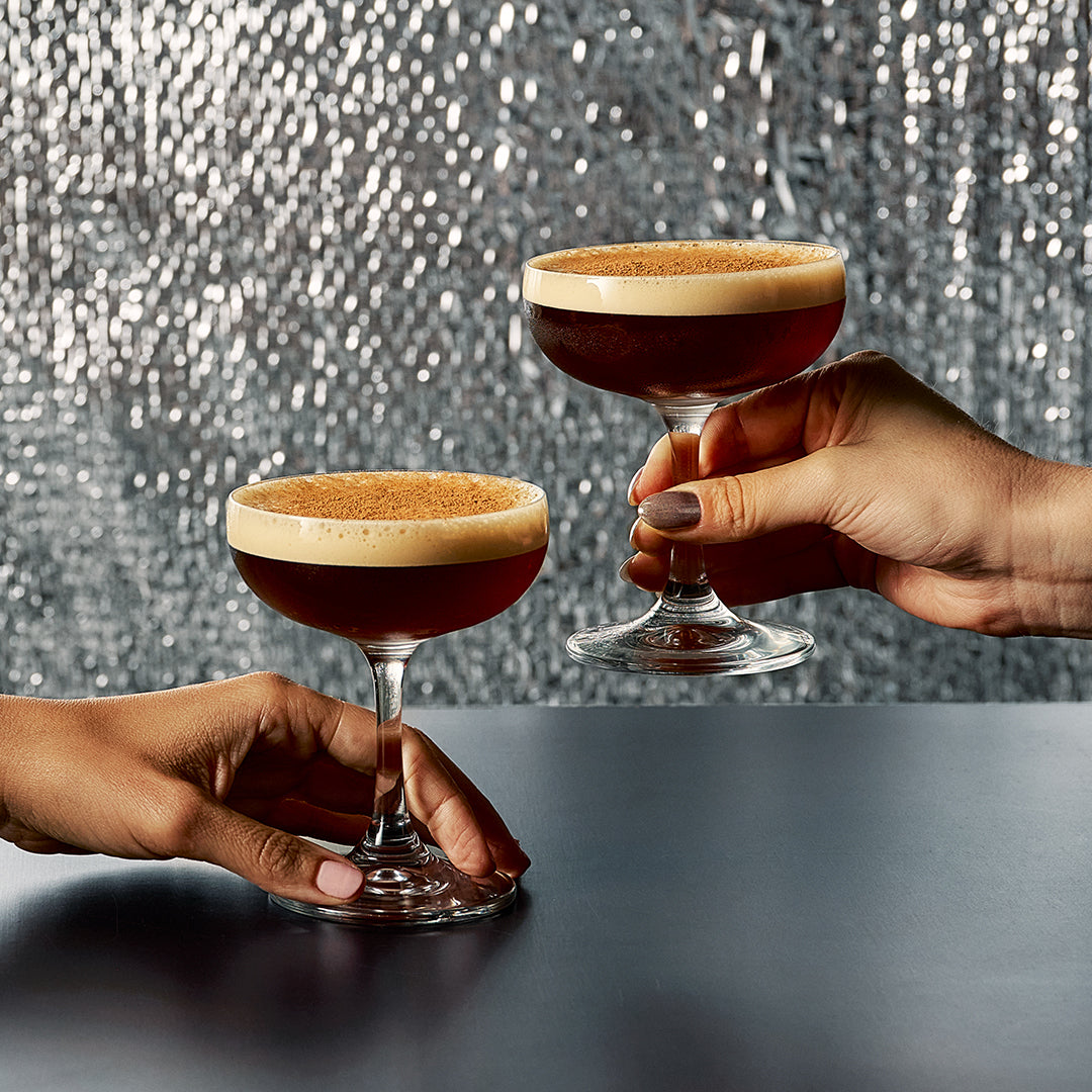 Two hands holding an Espresso Martini style cocktail made with Four Pillars x Lune Croissant Gin.