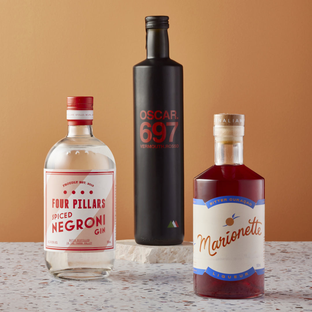 A Four Pillars Gin corporate gifting bundle made up of Spiced Negroni Gin, a bottle of Oscar 697 Vermouth Rosso, and a Marionette Bitter Curacao Liqueur. The perfect gift for a negroni lover.