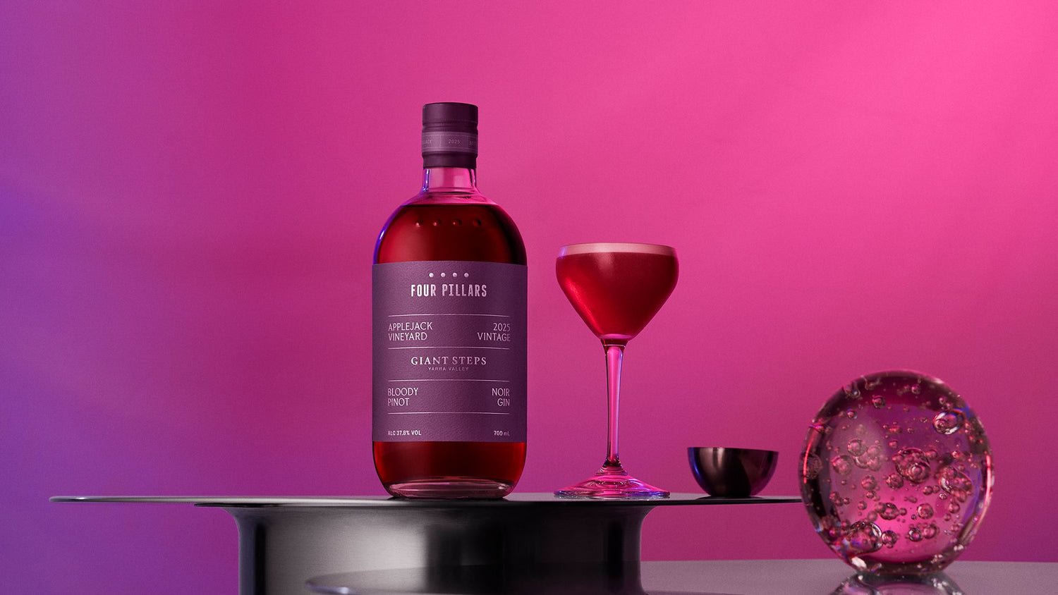 Bottle of Four Pillars Bloody Pinot Noir Gin with a pink gin sour cocktail and ice sphere.