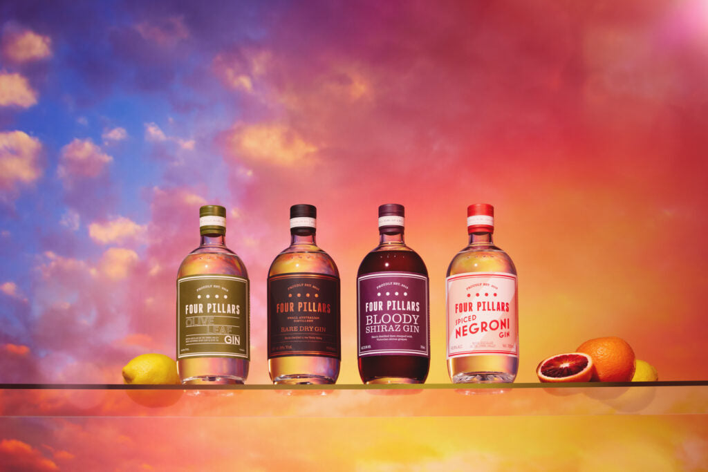 Four of Four Pillar's Gin's core range of gin in front of a colourful skyscape.